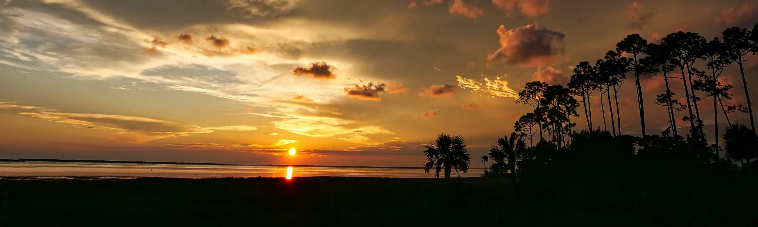 An illustration of a beautiful sunset from the shores of St. Joseph Bay in Simmons Bayou from a fish shack