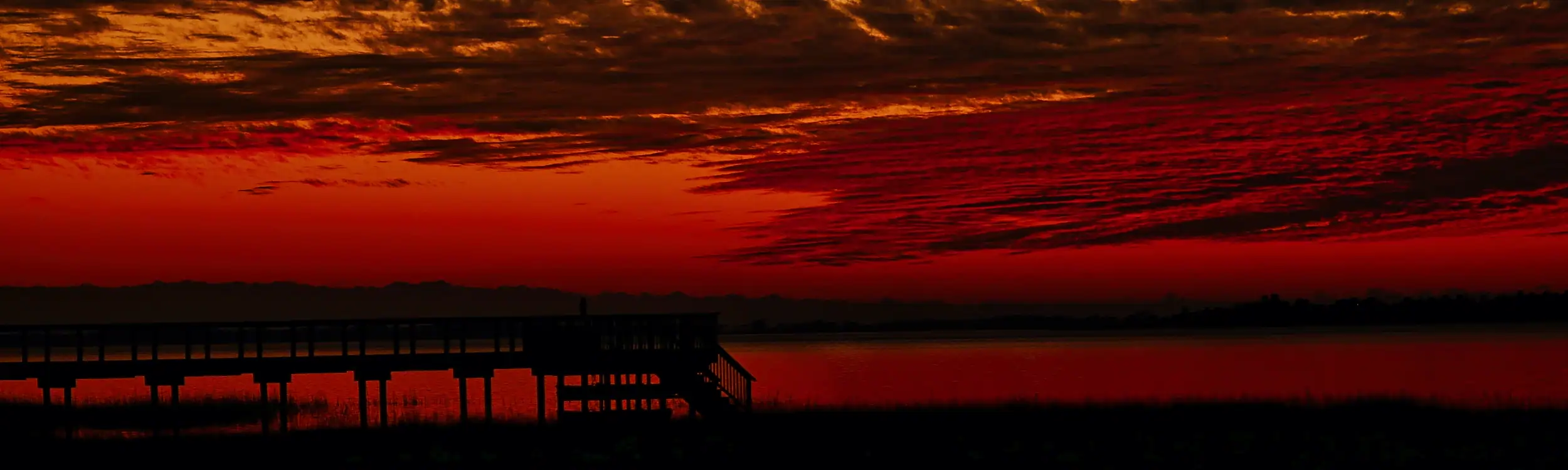 A silhoette of a pier at sunset